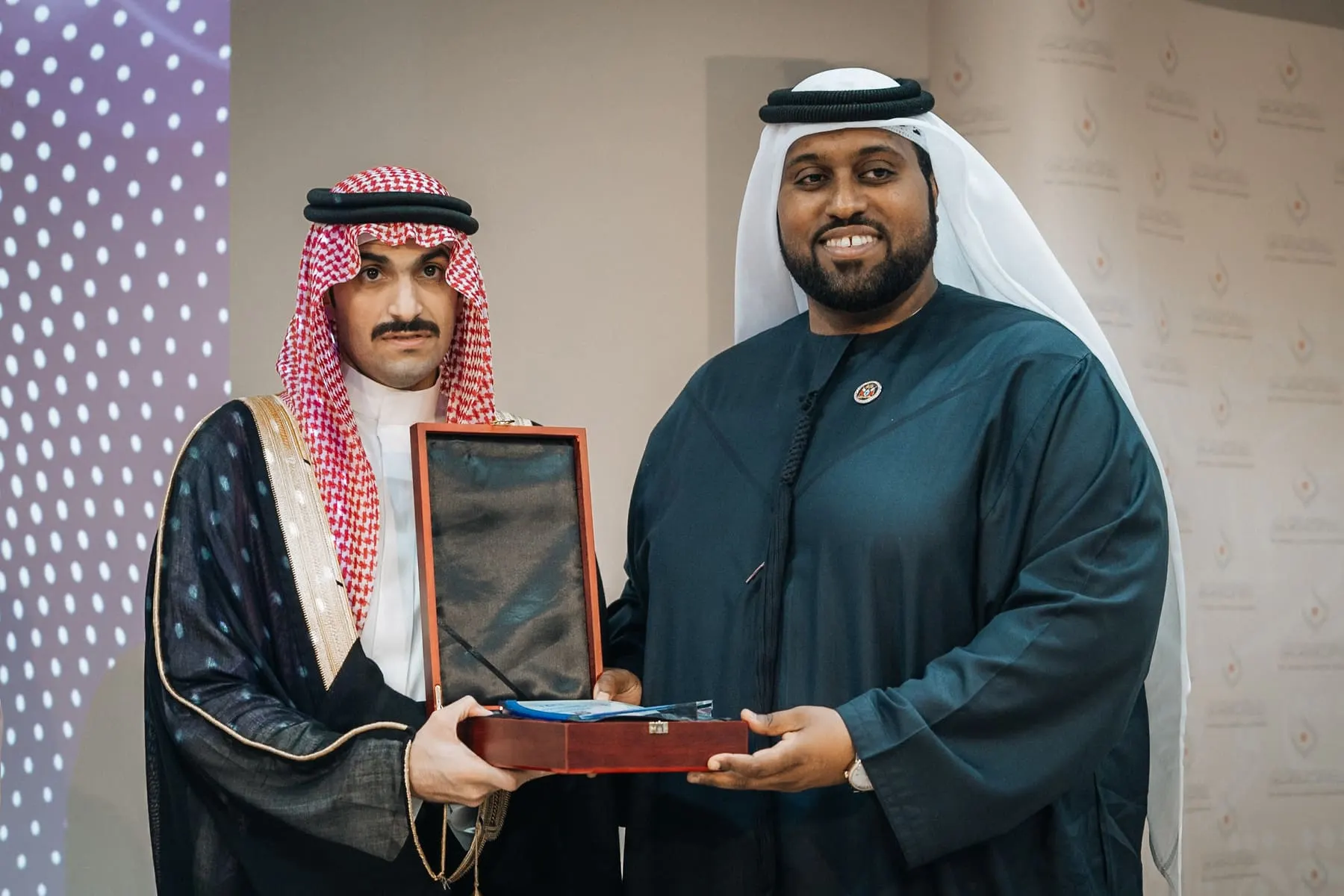 Guests in traditional dress presenting an award plaque — Al Matiya — Saudi event, The Cultural & Scientific Association, Dubai — Agency Verse