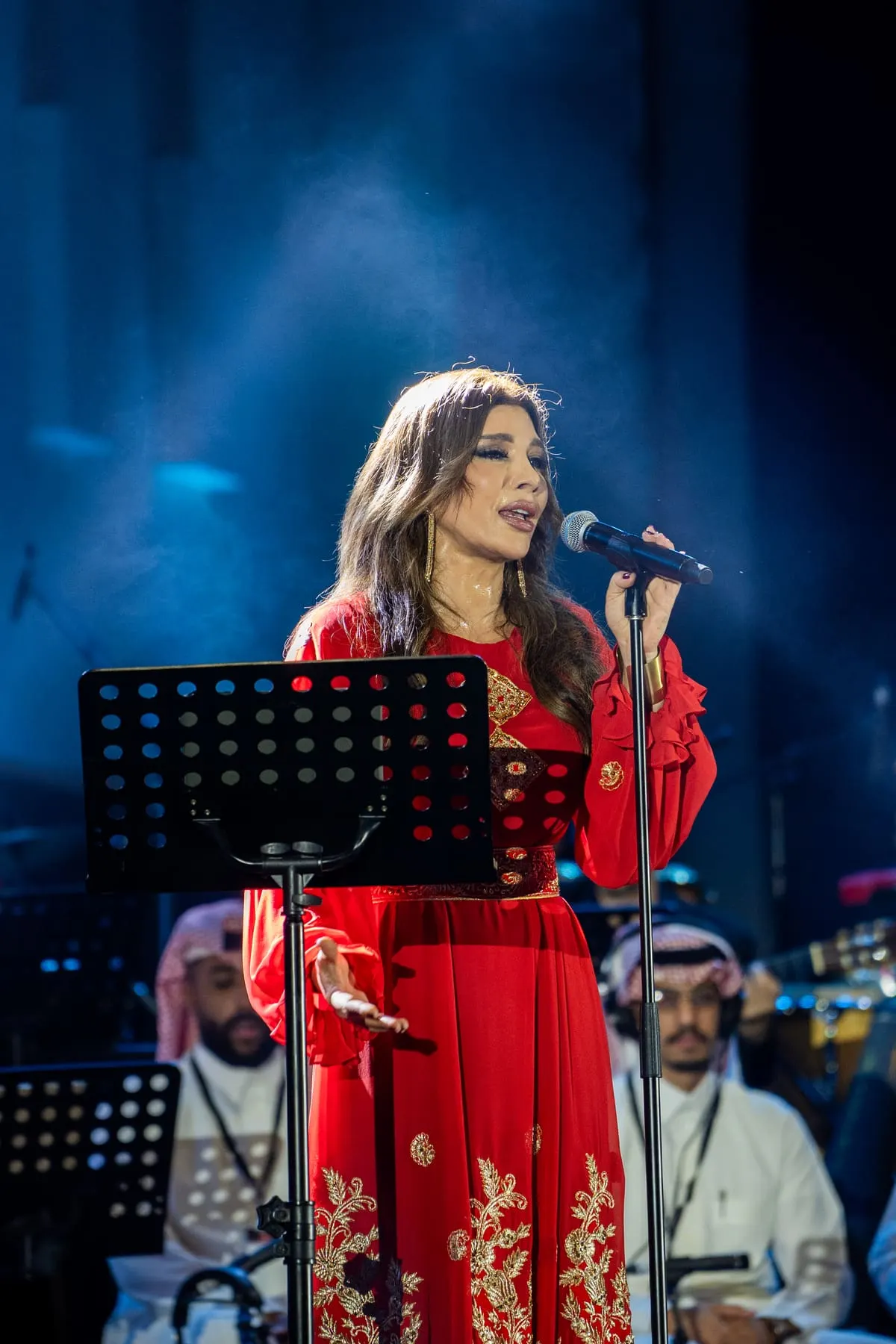 Singer performing under blue stage light — Assala — live at Sheikh Zayed Festival, Abu Dhabi — Agency Verse