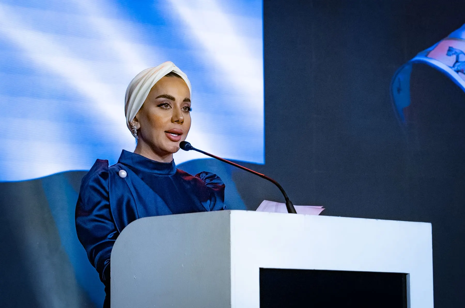 Signature talk / VSL films — Speaker at the lectern under blue stage light — Emirates Turkish Business Forum 2024, UAE — Agency Verse