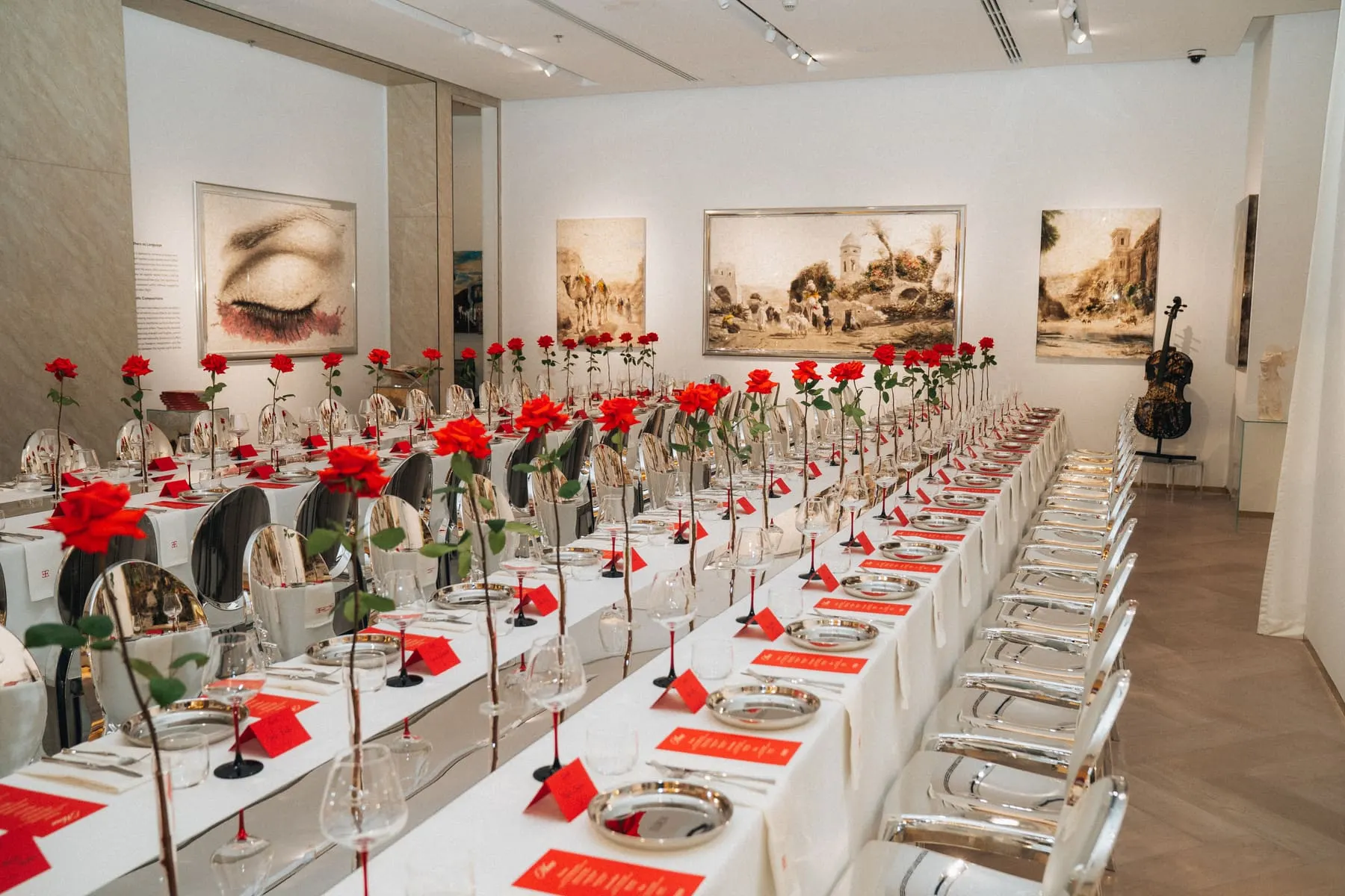 Long gala dinner table with red roses inside the gallery — Eden Gallery — Dubai Art Night — Agency Verse