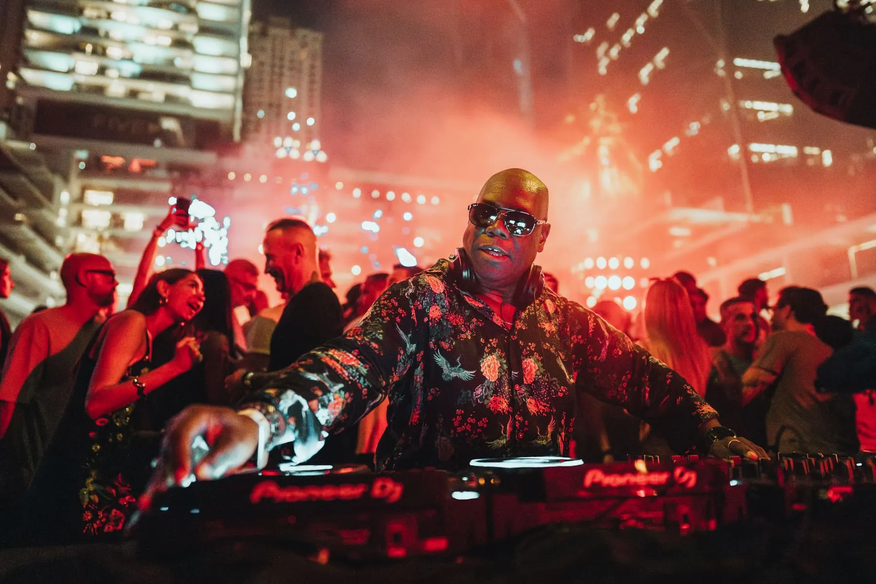 Carl Cox behind the decks with the crowd and red stage lights — Carl Cox — Pacha Icons, FIVE LUXE, FIVE LUXE JBR, Dubai — Agency Verse