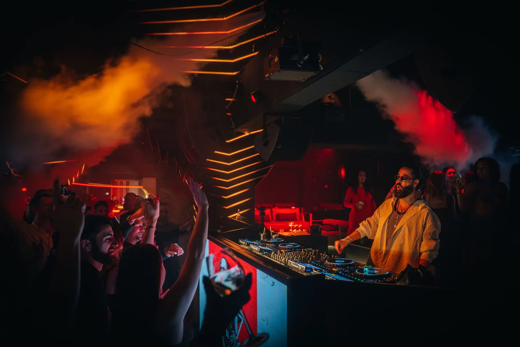 DJ performing through stage smoke and red light — FIVE Penthouse — Hamza, Dubai — Agency Verse