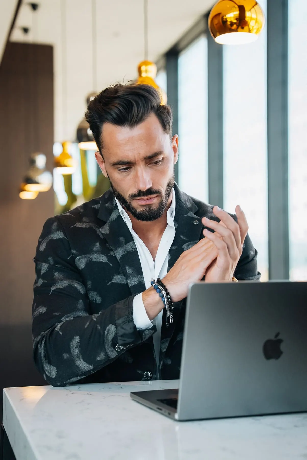 Founder in a camouflage blazer beside a laptop — GT Collection, Slovenia — Agency Verse