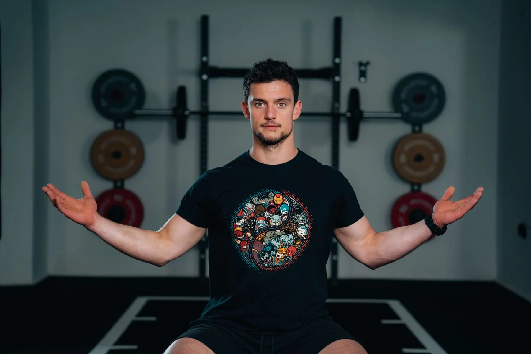 Coach with open arms seated in a gym studio — OptiForm — podcasts & courses, Slovenia — Agency Verse