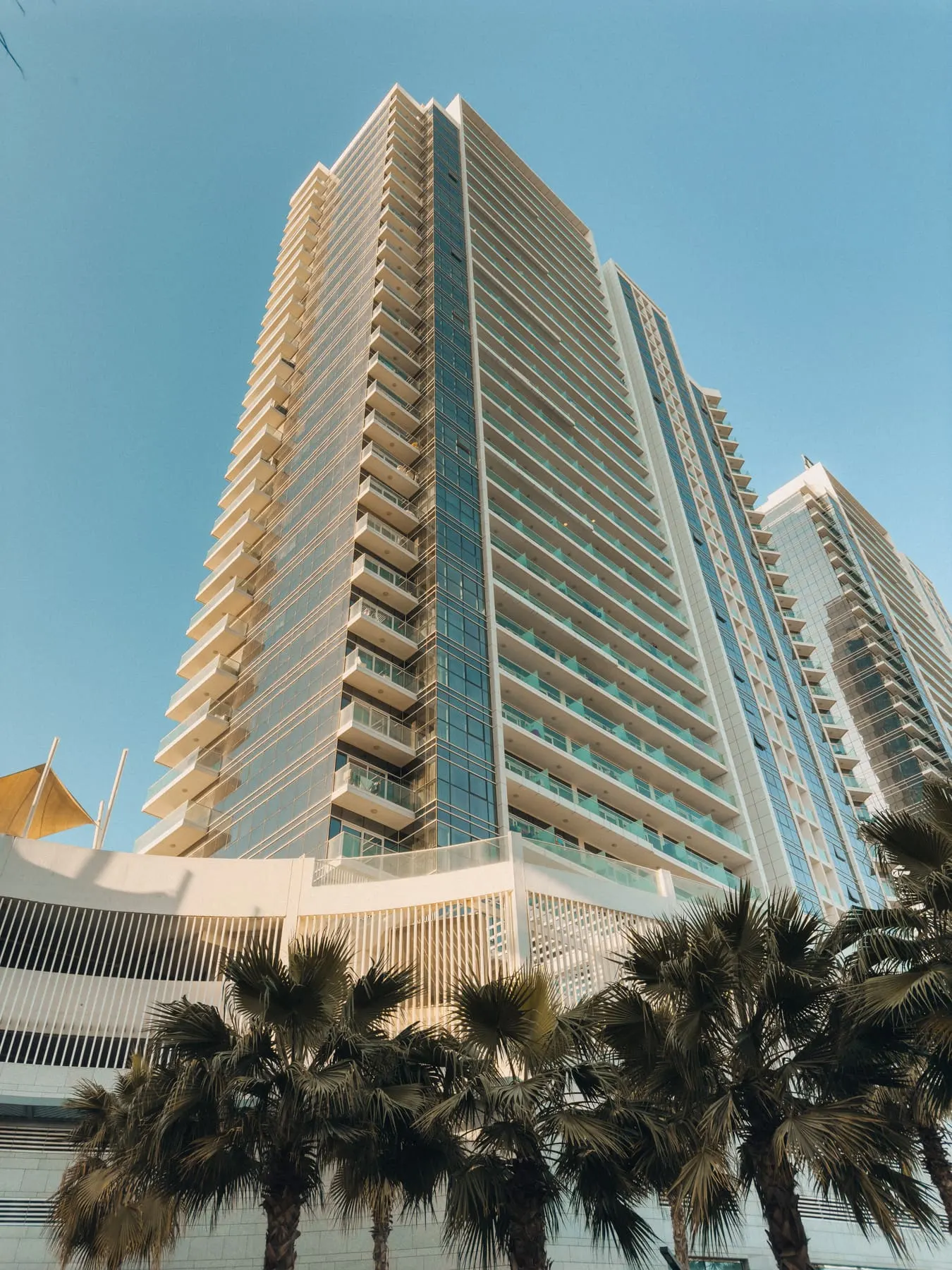 Cinematic property & development films — High-rise residential tower against a blue sky — Petro Deluxe — Agency Verse