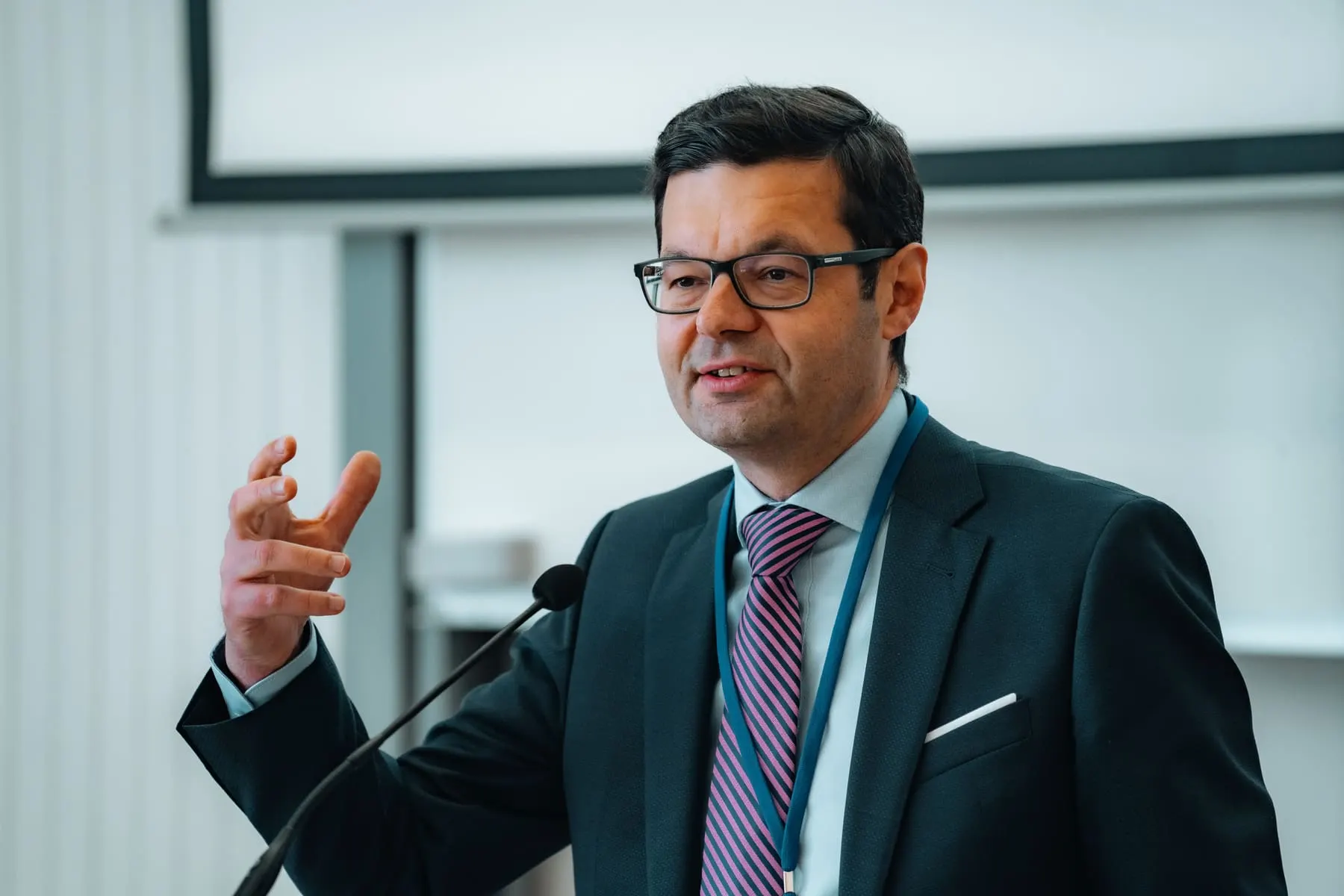 Conference, panel and speaking capture — Speaker addressing the conference at a microphone — Global Conference on AI & Human Rights — Agency Verse