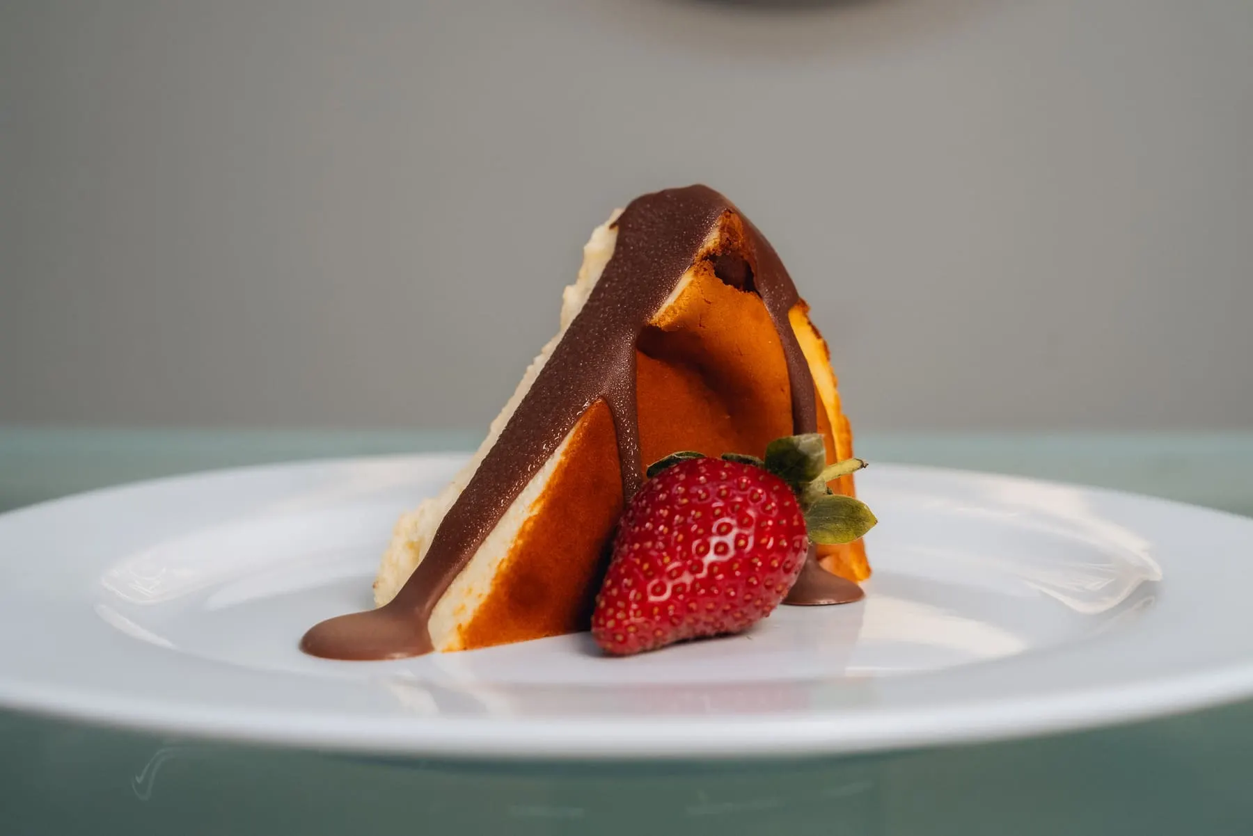 Slice of cake with a strawberry on a white plate — The Recipe Kitchen — Agency Verse
