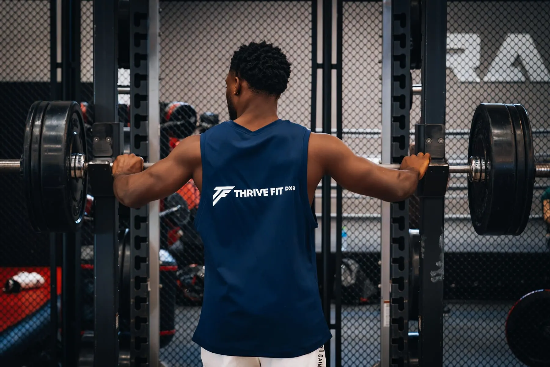 Class, gym & fight-night promos — Athlete training between weight racks — Thrive Fit DXB, Dubai — Agency Verse