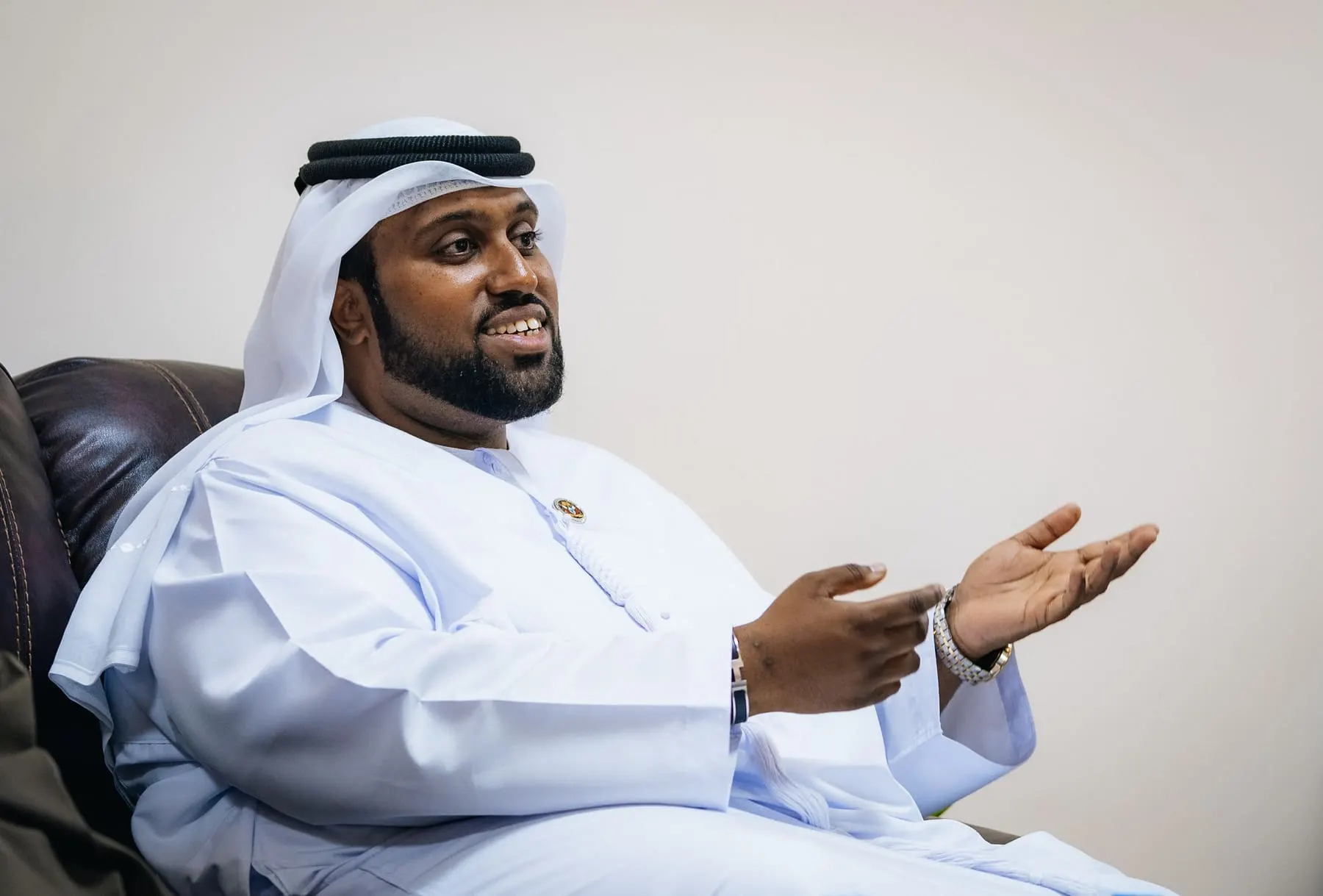 Emirati host speaking during an interview, seated in an armchair — Wadi Dafta Plantation — royal visit, UAE — Agency Verse